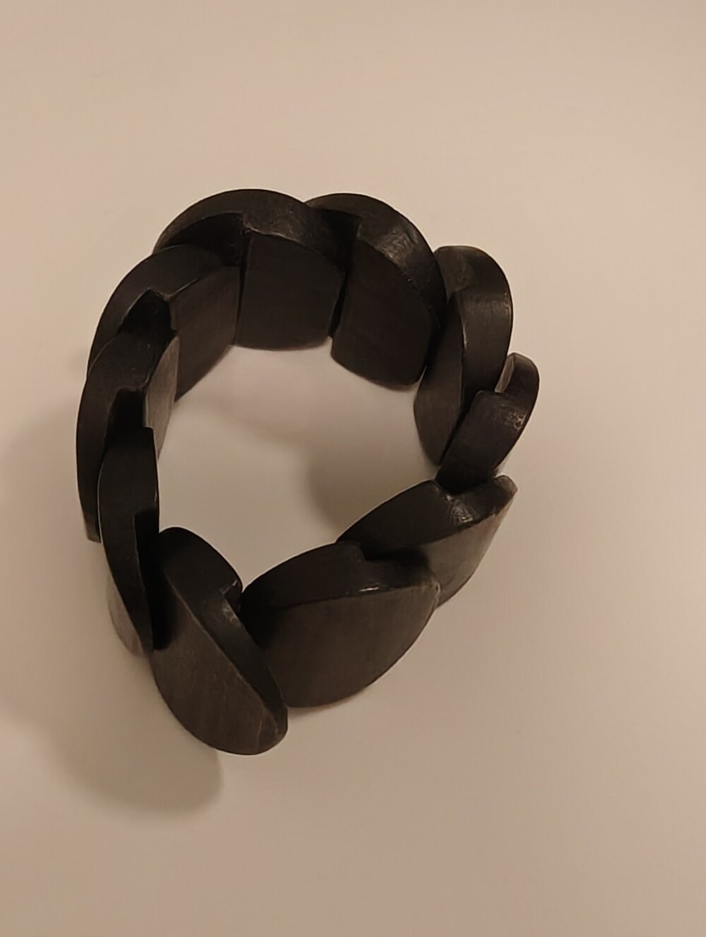 Black wooden stretch bracelet features distinctive geometric disc links
